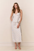 Woman wearing a striped dress against a plain background