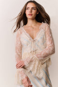 Woman wearing a lace dress with a plain background