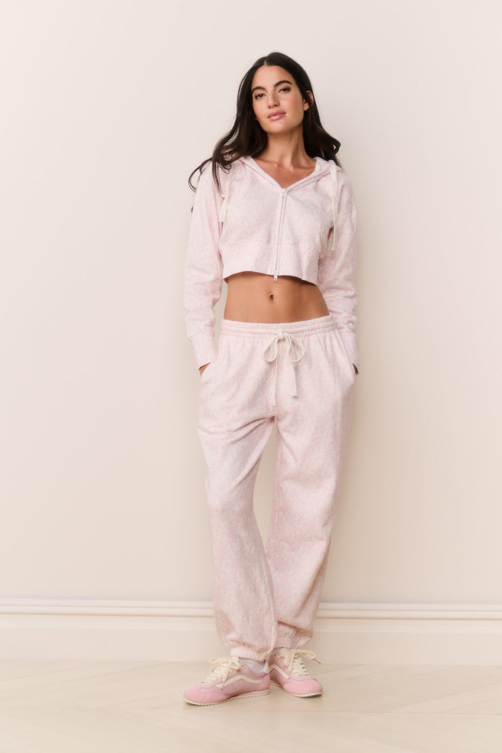 Woman wearing a light pink pajama set against a white background