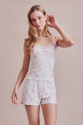 Woman wearing a floral pajama set against a beige background